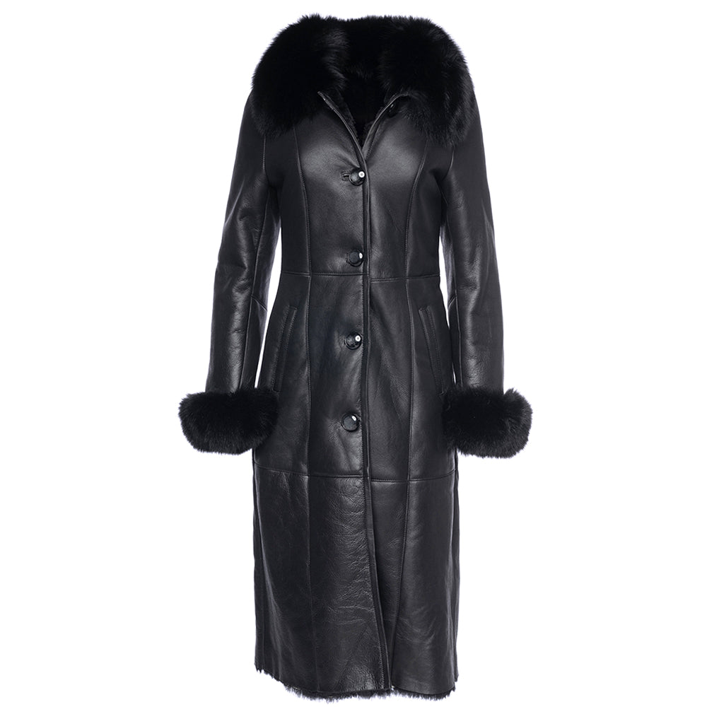 A full-length black shearling sheepskin coat with fox fur trim on the cuffs and collar, featuring a buttoned closure and two functional front pockets.