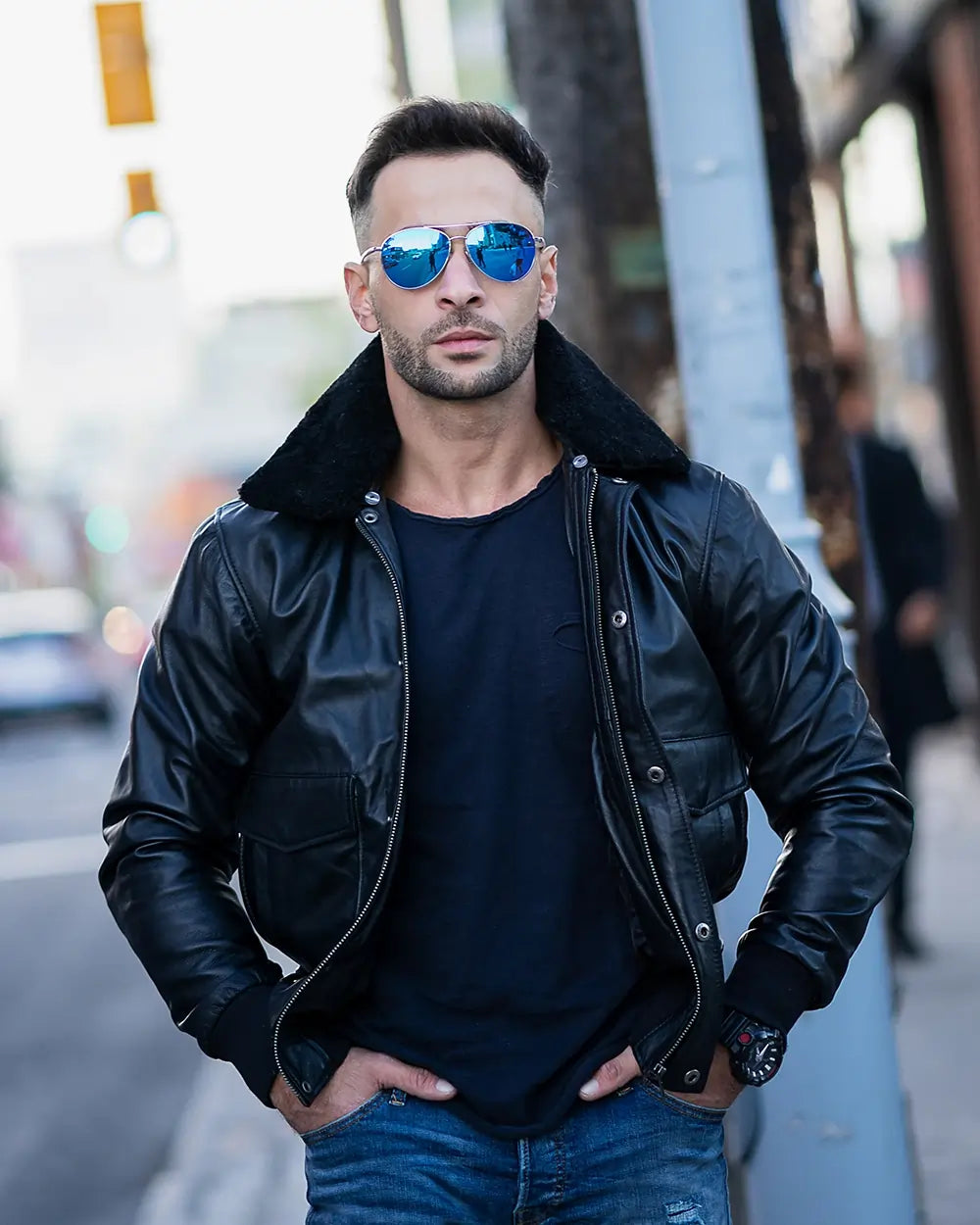 Men's black A2 Bomber Aviator leather jacket styled with blue jeans and sunglasses for a modern military-inspired look.