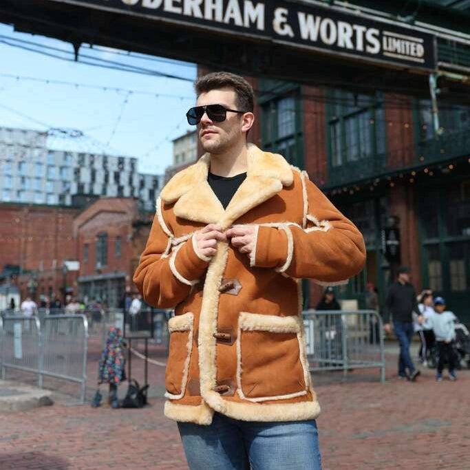 Man wearing a brown shearling jacket in front of Gooderham & Worts Limited sign.