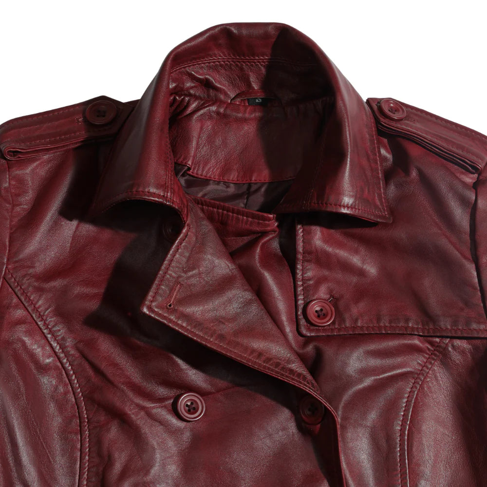 Close-up of the elegant notched lapel collar and precision edge-stitching on the coral red belted coat.