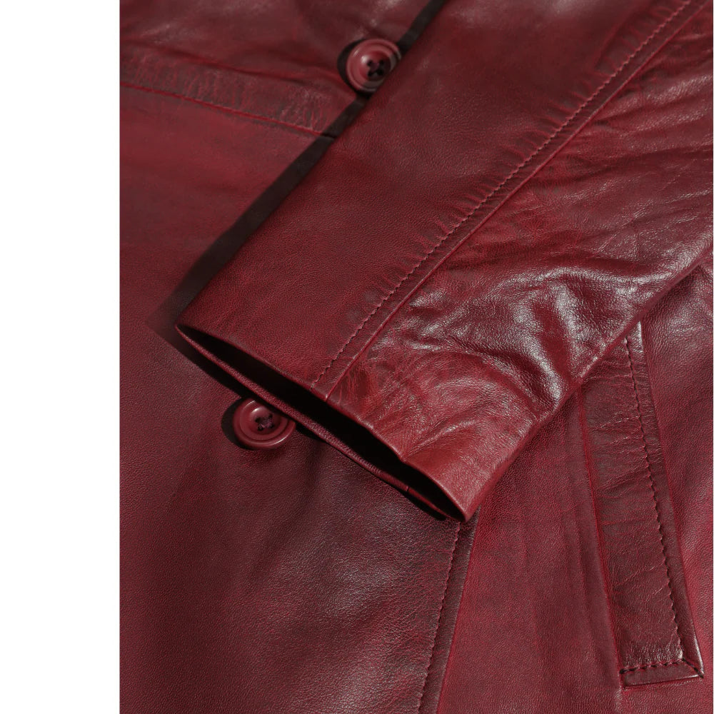 Close-up of a red leather jacket showcasing leather sleeves with buttons on a white background
