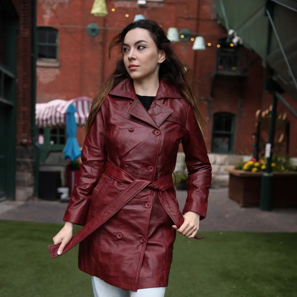Lifestyle photoshoot of a woman wearing a coral red belted leather coat, styled as a vibrant statement piece for urban street fashion.