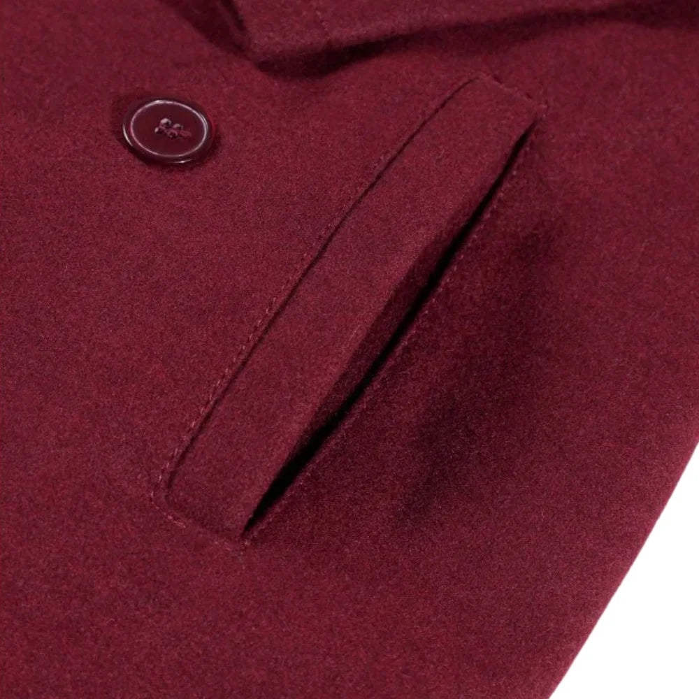 Close-up of a burgundy wool overcoat coat pocket with a button on a white background.