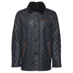 A navy quilted sheepskin shearling coat with a shirt style fur collar, buttoned up closure, and two functional outer pockets.