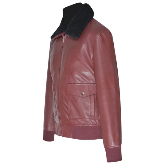 Side profile of a men's burgundy leather bomber jacket showcasing the sleeve construction, ribbed cuffs, and the classic aviator silhouette on white background.