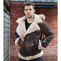 Man wearing Rocco vintage brown aviator shearling jacket with white fur lining against a brick wall.