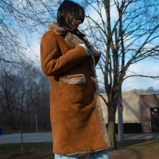 Model side view wearing Sabina Tobacco Oversized Long Shearling Coat long shearling coat profile