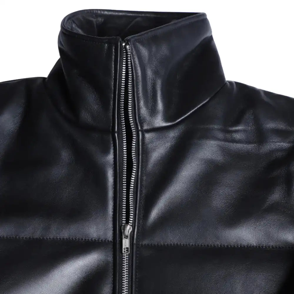 Close-up of the Sorine jacket’s premium black leather, highlighting the soft sheen, fine stitching, and concealed zipper pockets.