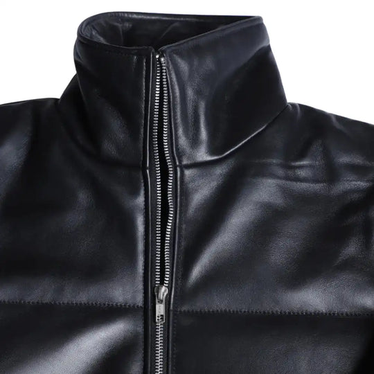 Close-up of the Sorine jacket’s premium black leather, highlighting the soft sheen, fine stitching, and concealed zipper pockets.