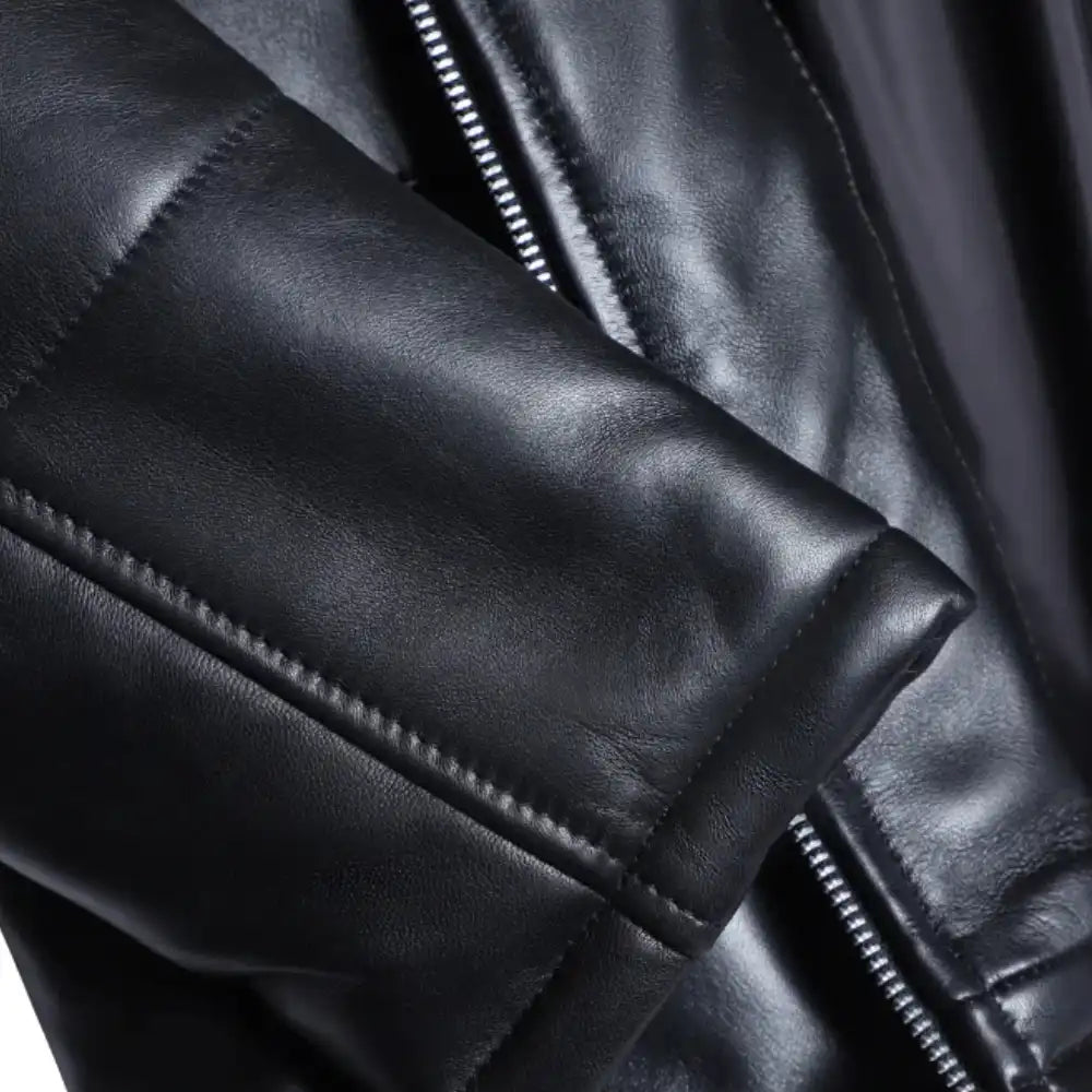 Close-up of the Sorine jacket’s premium black leather, highlighting the soft sheen, fine stitching, and concealed zipper pockets.
